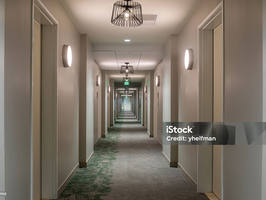 Langer Flur mit vielen gleichen Wohnungstüren